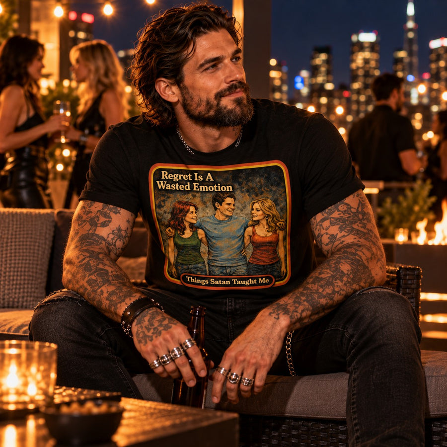 Model sitting in the Regret Is A Wasted Emotion tee in black by Things Satan Taught Me