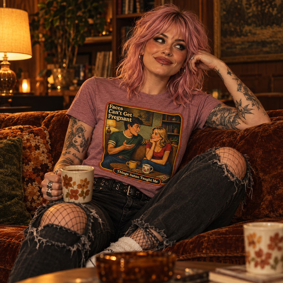 Model sitting in the Faces Can't Get Pregnant tee in heather mauve by Things Satan Taught Me