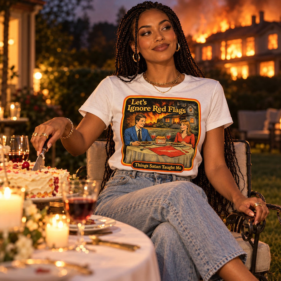 Model sitting in the Let's Ignore Red Flags tee in white by Things Satan Taught Me